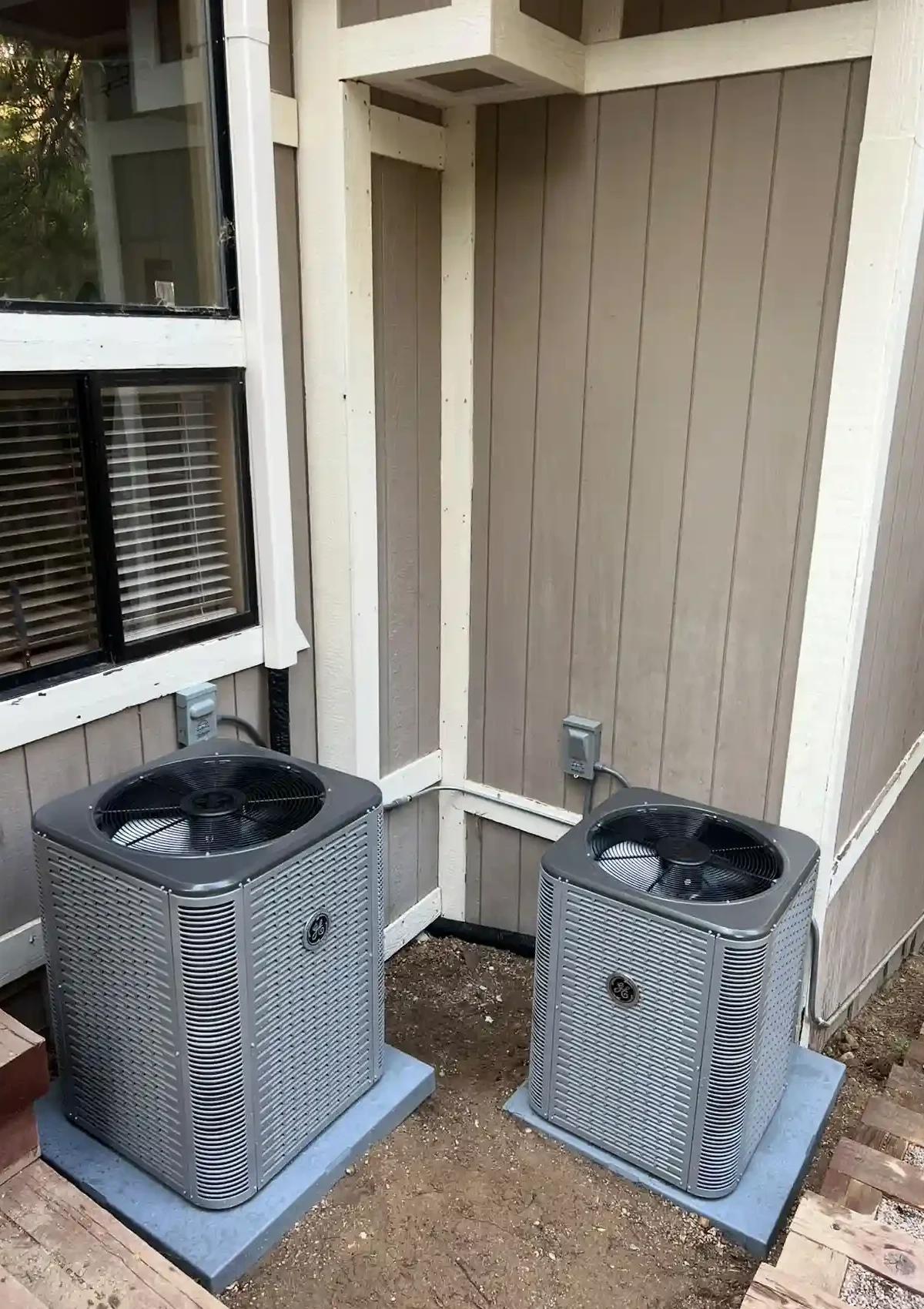 Two air conditioning units outside a home.