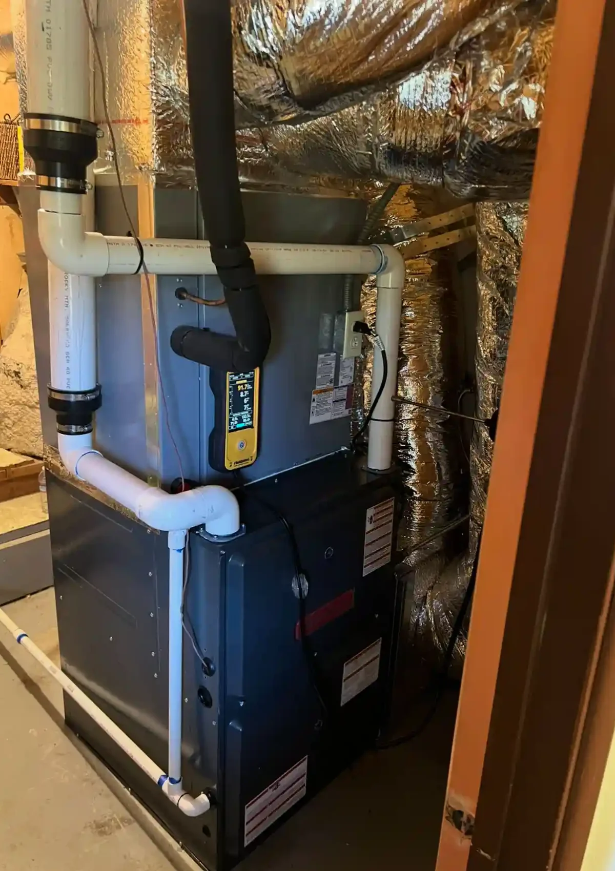 Complex heating system freshly repaired and surrounded by ductwork.